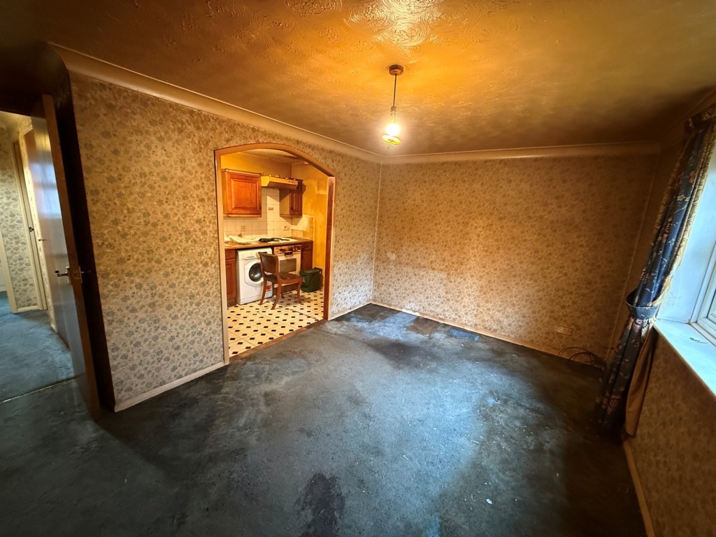 Lot: 146 - VACANT ONE-BEDROOM FIRST FLOOR FLAT FOR IMPROVEMENT - Living room showing archway to kitchen and entrance hall